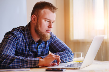 Young man working on laptop at home