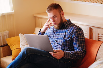 Young man working absorbed on laptop at home