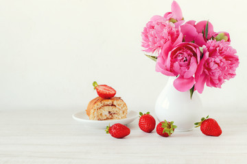 Still life with pink peonies, strawberries and cake