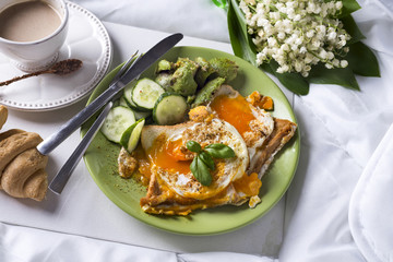 Fried eggs with toasts and tea in bed