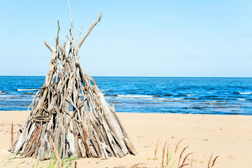 Wigwam Made from wooden branches on the sand of baltic sea beach