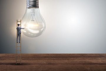 Businessman on ladder with light bulb