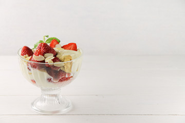 Strawberry dessert with yoghurt, almond shavings and mint