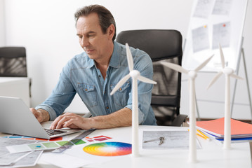 Pleasant engineer using laptop