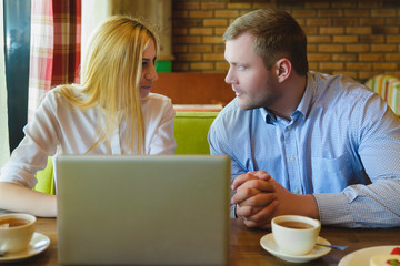 Business meeting in a cafe. Man and woman are negotiating