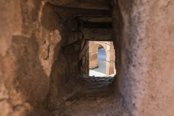 View of the ancient arch through the embrasure in the wall of the fortress