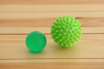 Two rubber balls on light wooden background