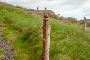 Iron post and barbed wire fence mark the boundary in rural Ireland