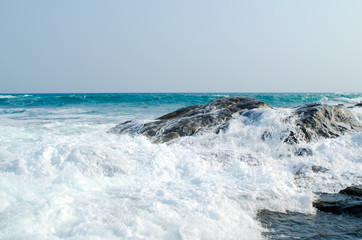 The sea wave is crashed about the shore and rocks
