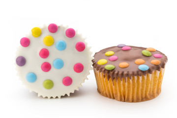 Multiple colorful decorated muffins on a white background.
