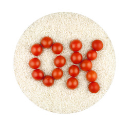 The word OK made from tomatoes on the background of rice groats in white circle