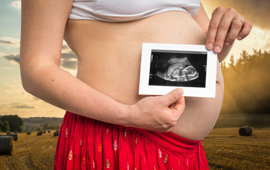 Belly of a pregnant woman and ultrasound scan of baby