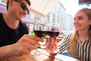 Young couple with glasses of red wine in a restaurant with city view