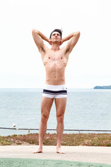 Fototapeta na wymiar Strong muscular Men, perfect body, abs, six pack, sea, beach, swimwear