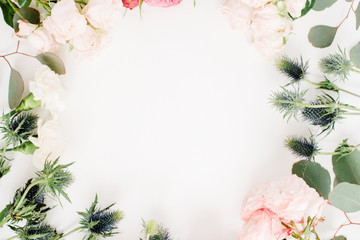 Round frame wreath made of red and beige rose flowers, eringium flower, eucalyptus branches and leaves isolated on white background. Flat lay, top view. Floral background