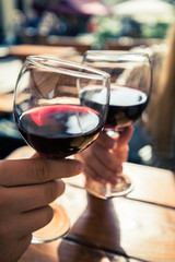 Young couple with glasses of red wine in a restaurant with city view