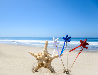 Fototapeta na wymiar Patriotic USA background with starfish on the sandy beach