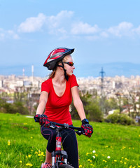 Escape urban . Bicycle girl has rest from city bustle. Woman wearing sport helmet rides returns...