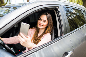 Fototapeta na wymiar woman hand holding smartphone on window her car