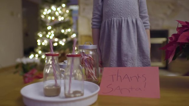 Little Girl Places Thank You Card To Santa Next To Hot Cocoa And Treats 
