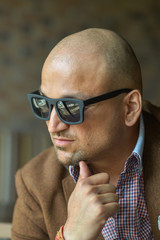 portrait of a hansome indian businessman wearing sunglasses, serious young man thinking