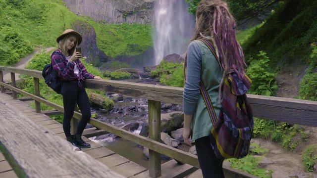 Hiker Takes Photos Of Her Friend On A Bridge With Beautiful Waterfall In Background