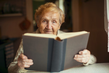Russian elderly woman reading a book.
