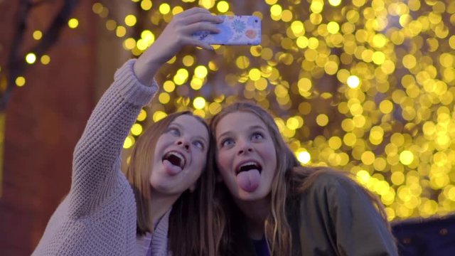 Fun Teen Girls Pose For Selfies In Front Of Beautiful Lights, They Look At Photos Afterward
