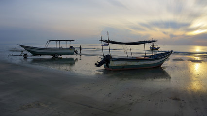 Naklejka premium fisherman boat on sunrise at beach