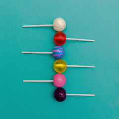 Lollipop Flat lay Minimal concept Six colorful round lollipops are lying in a row on a light blue background One-color and two-color candies