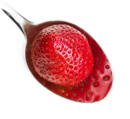 Strawberry in a silver spoon with reflection
