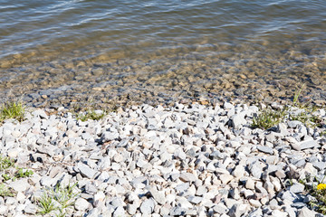 lake water stones sun and flowers
