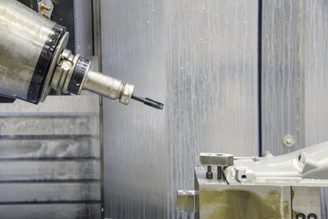 The 5-axis CNC  milling machine  tapping the automotive part with the tapping tool.Hi-technology machining concept.