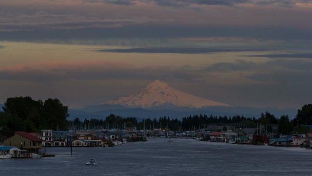 Time lapse video of moving clouds over snow covered mt. hood and Columbia river gorge with residential boathouses in Hayden Island 4k uhd