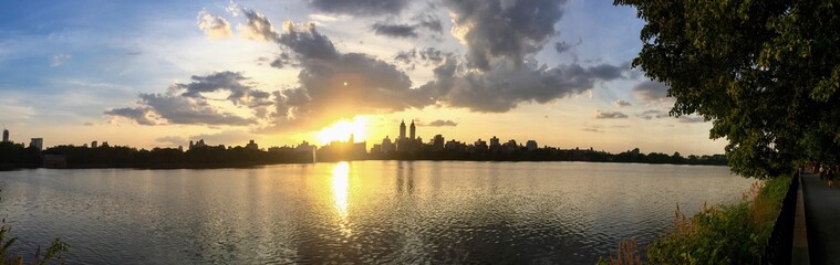 Fototapeta na wymiar Jacqueline Kennedy Onassis Reservoir and silhouette building with sunset in panorama