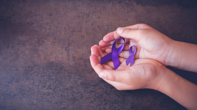 hands holding Purple ribbons,toning copy space background, Alzheimer's disease, Pancreatic cancer, Epilepsy awareness, Hodgkin's Lymphoma awareness, panoramic banner