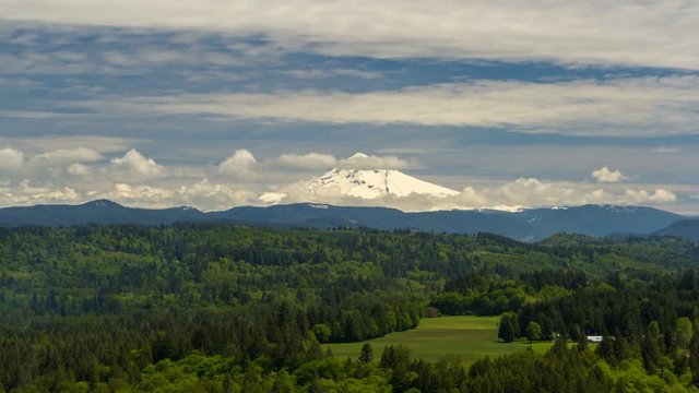 Ultra high definition 4k timelapse movie of moving white clouds and blue sky over majestic snow covered Mt. Hood and Sandy river valley in Portland Oregon spring season 4096x2304