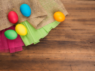 Easter eggs on old brown wood background with borlap and green paper. Top view, horizontal. Mock up for your poster. Russian and Ukrainian, orthodox, slavic traditional Easter, rural background.