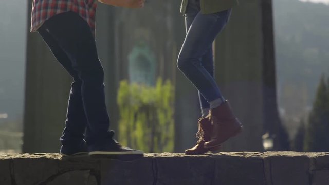 Closeup Of Couple's Feet/Legs As They Balance On Rock Wall And Dance Together