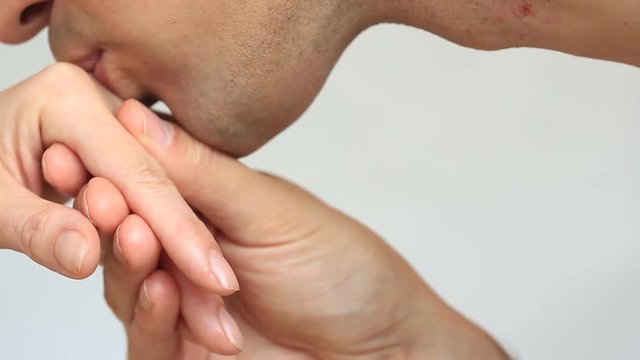 Close-up of a kiss for hands. The man kisses the woman's hand. Isolated over white background