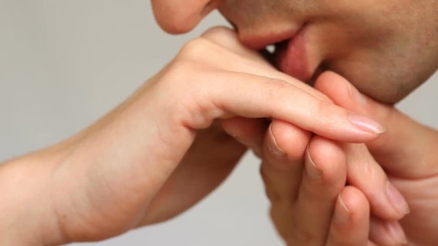 Close-up of a kiss for hands. The man kisses the woman's hand. Isolated over white background