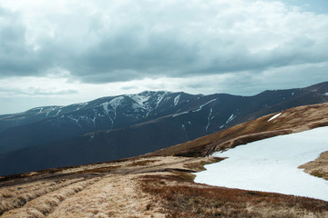 Landscape of great snowy peak of the mountains in spring in the cloudy day