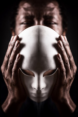 Dramatic art portrait of african black man with white mask.