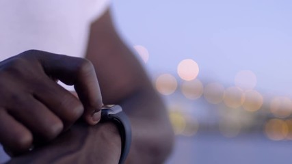 Closeup Of Man using His Smartwatch With City Lights In Background - Powered by Adobe