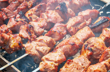 Shish kebab is baked over a fire with smoke. Camping and delicious food