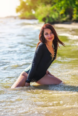 Beautiful attractive sexy girl posing on the beach in sunny hot day