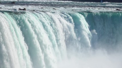 CLOSE UP Powerful raging whitewater waterfall falling forcefully over a rocky edge. Crystal clear glacier water stream dropping over the steep vertical cliff. Misty majestic Niagara Falls river rapids