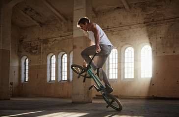BMX stunts in a sunray indoor gothic hall.
