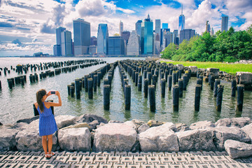 New York tourist woman taking mobile picture with smartphone. Manhattan city skyline waterfront...