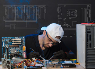 man is engaged in repair of computers